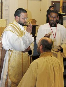 Newly ordained Fr Jean  Marie blesses one of his religious brothers.