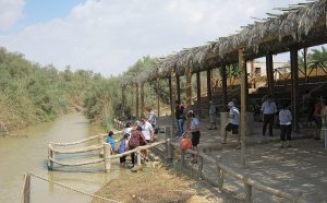 Pilgrims go into the Jordan River near where Jesus was baptised by John. 