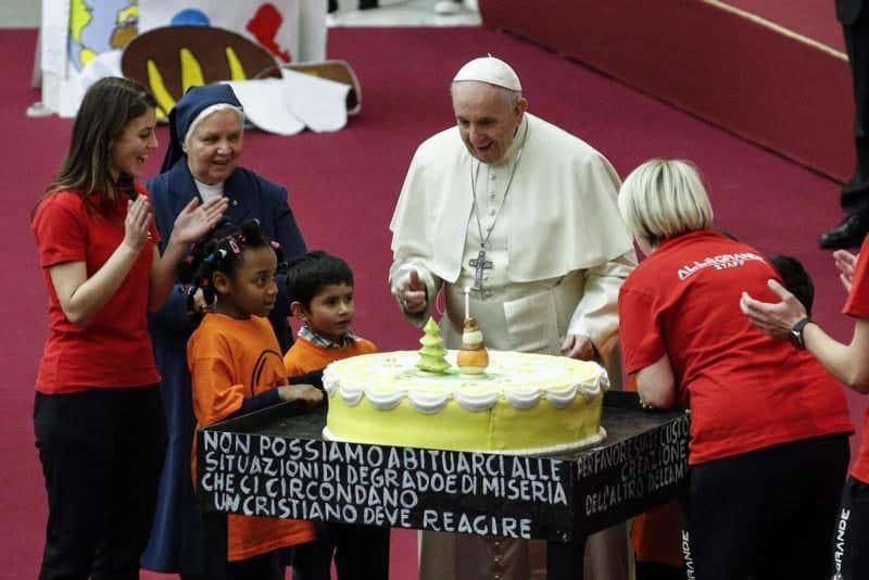 Pope Francis is presented with a cake on the eve of his 82nd birthday during a Dec. 16 audience with children and families from the Santa Marta Dispensary, a Vatican charity that offers special help to mothers and children in need. (CNS photo/Giuseppe Lami, EPA) See POPE-CLINIC-CHILDREN Dec. 17, 2018.
