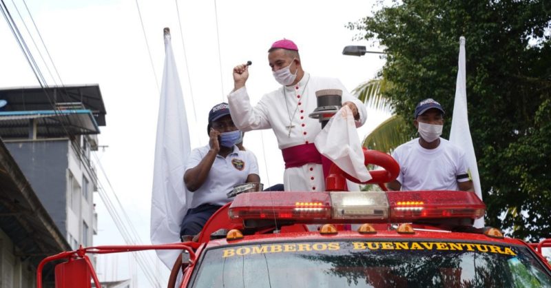 Colombian Bishop Rubén Darío Jaramillo Montoya of Buenaventura rides atop a firetruck during a protest against growing drug violence Feb. 10, 2021. The bishop boarded the firetruck to spray the town's main street with holy water and help it to "cleanse it" of evil. (CNS photo/courtesy Diocese of Buenaventura)