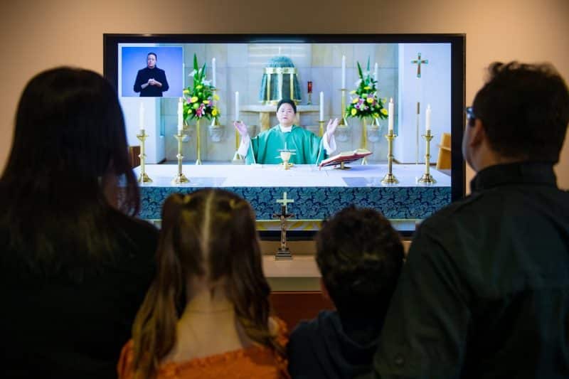 A Sydney family watches "Mass For You at Home" on television during the latest COVID-19 lockdown Aug. 1, 2021. After 50 years of broadcasting, the Mass has become the longest-running program on Australian television. (CNS photo/Giovanni Portelli, The Catholic Weekly)