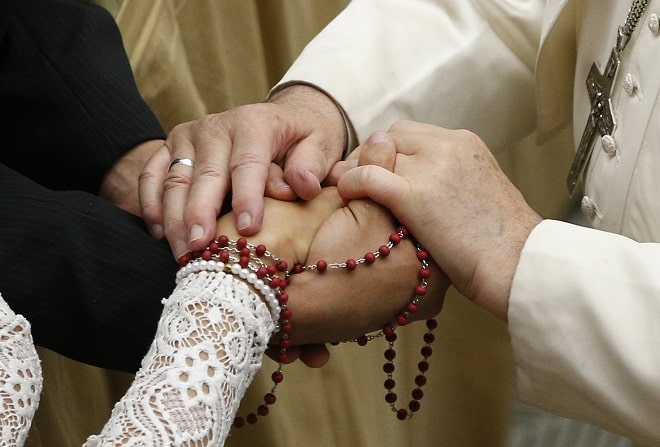 Pope Francis touches the hands of a newly married couple during his general audience in Paul VI hall at the Vatican Dec. 18, 2019. The Dicastery for Laity, the Family and Life has released guidelines and suggestions for developing a "matrimonial catechumenate," a yearlong preparation for marriage and family life. (CNS photo/Paul Haring)