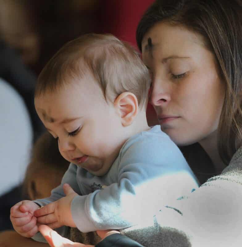 A mother is pictured in a file photo praying while holding her baby during Ash Wednesday Mass at Jesus the Divine Word Church in Huntingtown, Md., March 6, 2019. All mothers are honored in special ways on Mother's Day, which is May 14 this year. (OSV News photo/CNS file, Bob Roller)