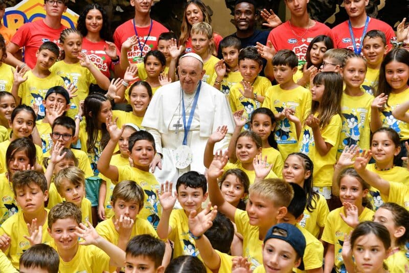 Pope Francis poses for a photo with children in the Vatican's Paul VI audience hall July 18, 2023. About 250 children of Vatican employees are attending a summer program July 3-Aug. 4. (CNS photo/Vatican Media)